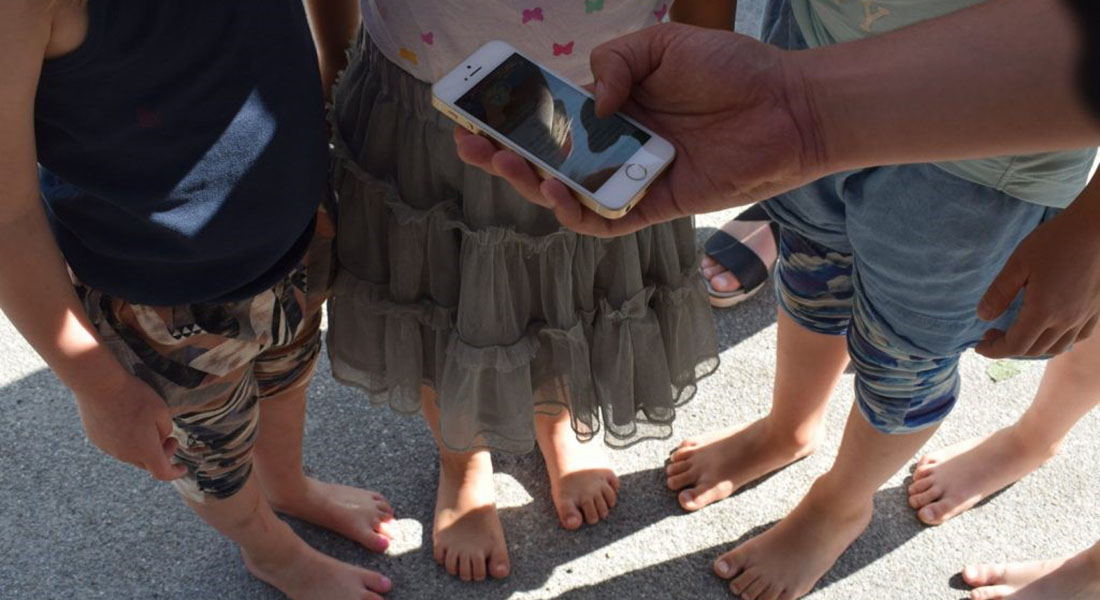 Børn samlet om mobil